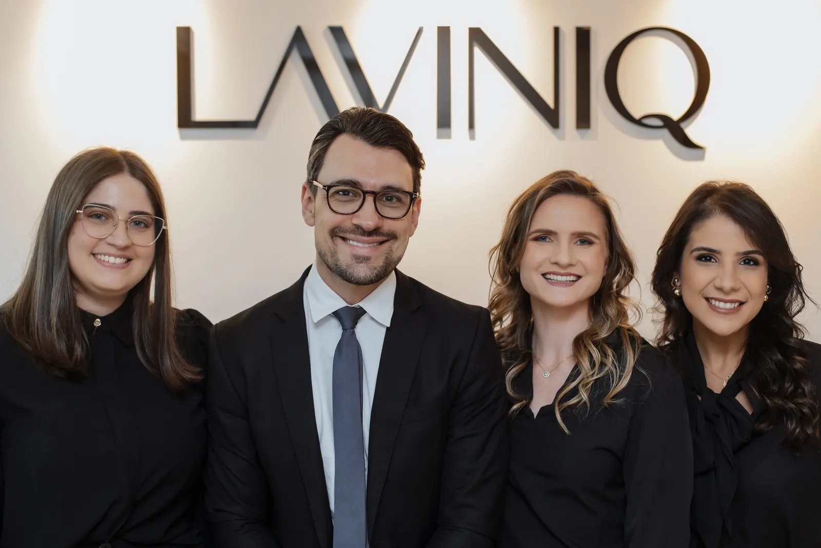 Dra. Sabrina Timm, Dr. Rafael Giacobbo, Dra. Lisiane Pfeifer e Dra. Bruna Rockenbach em frente ao logo da Laviniq